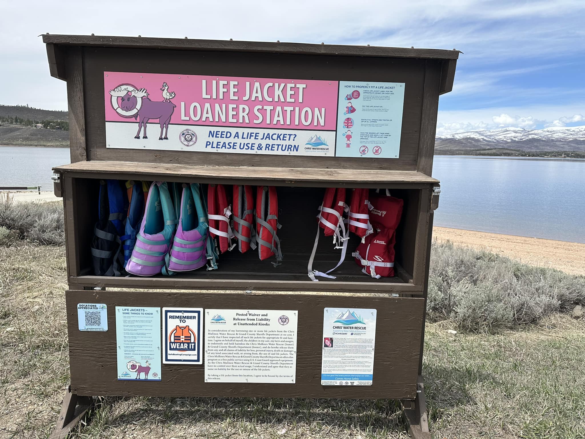 Life Jacket Loaner Station with several sizes of life jackets near a reservoir in Grand County, CO
